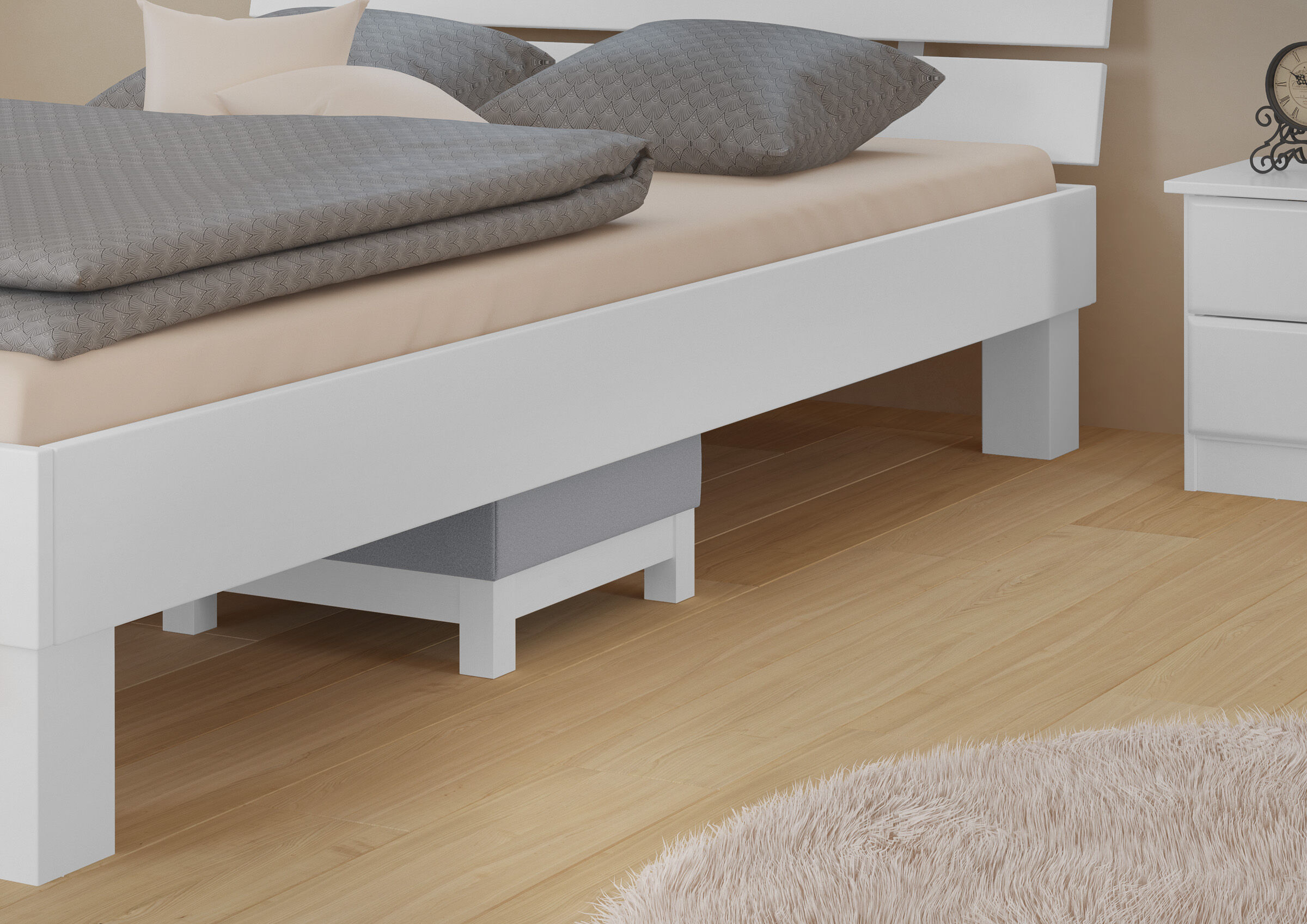 Boxspringbetten, weißer Rahmen, beige Bettwäsche, graue Kissen, Holzboden, grau-weißer-Hocker